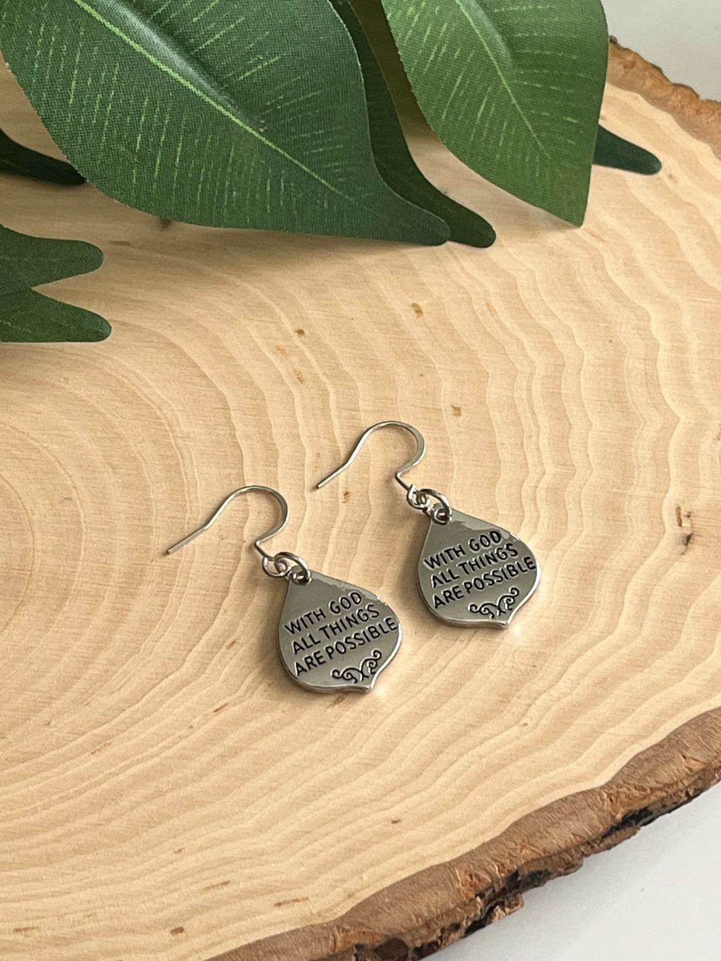 Silver dangle earrings with “With God all things are possible” engraving on small round charms.