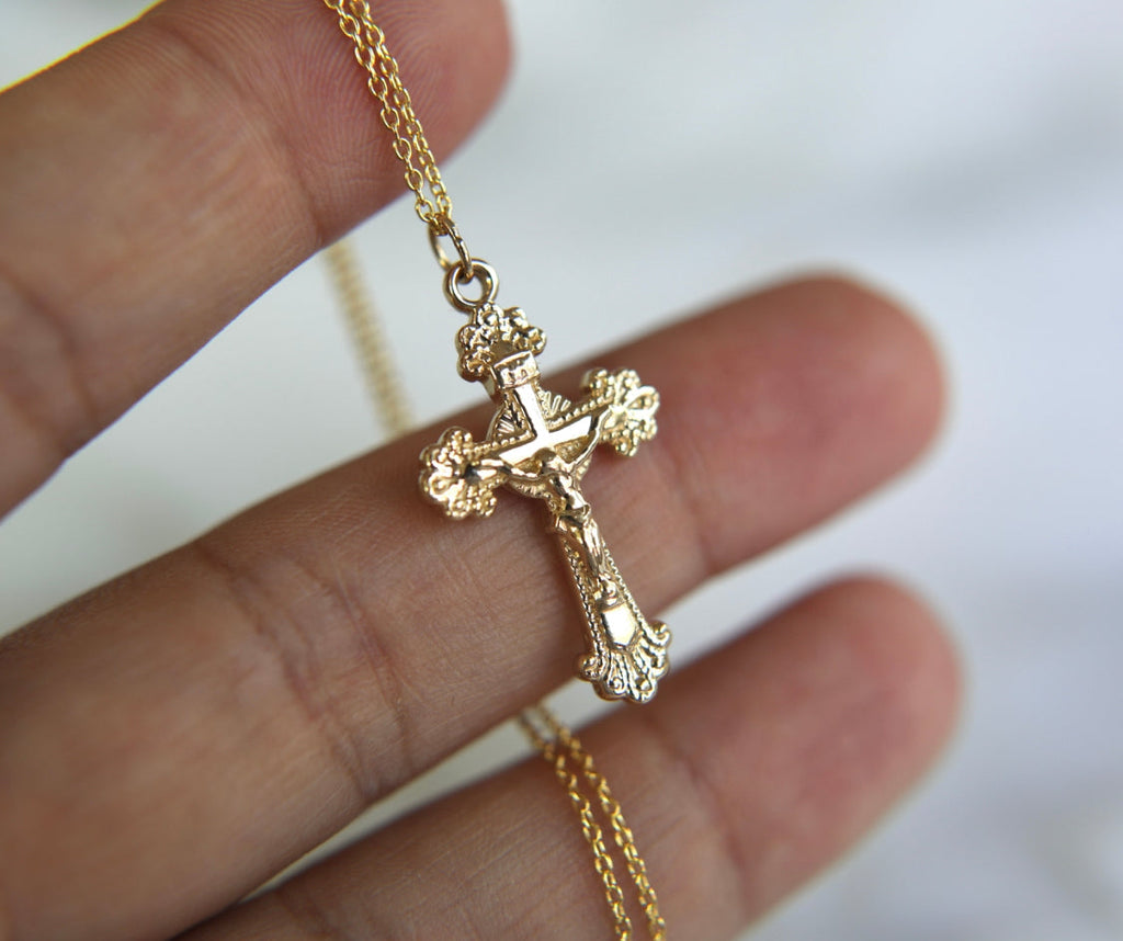 14k gold crucifix pendant on a link chain, angled view of the cross.