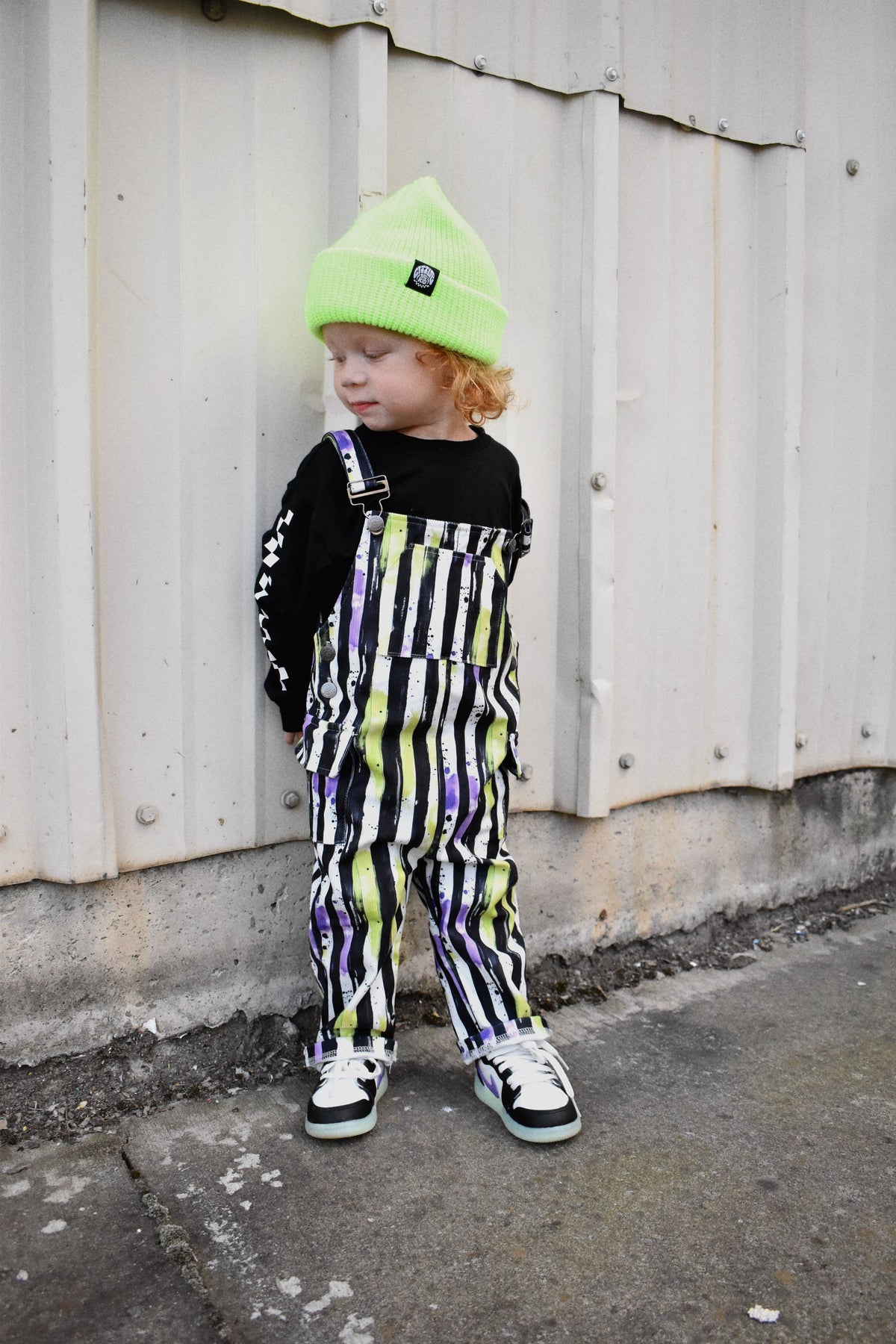 Kids Halloween overalls with adjustable straps and black, white, neon green stripes