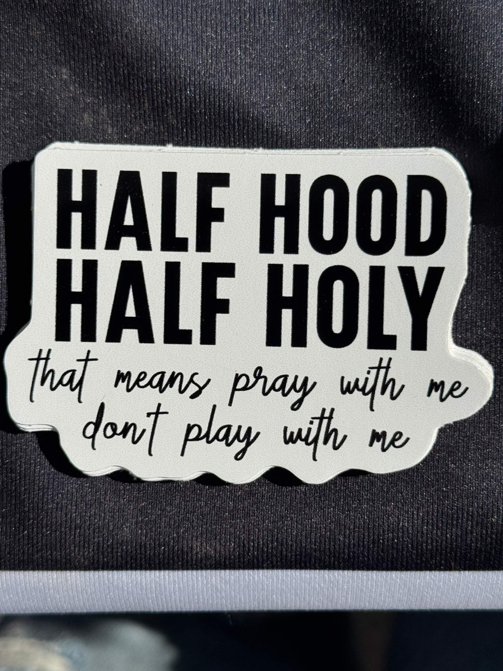 Vinyl sticker reading 'HALF HOOD HALF HOLY' with handwritten 'pray with me' text