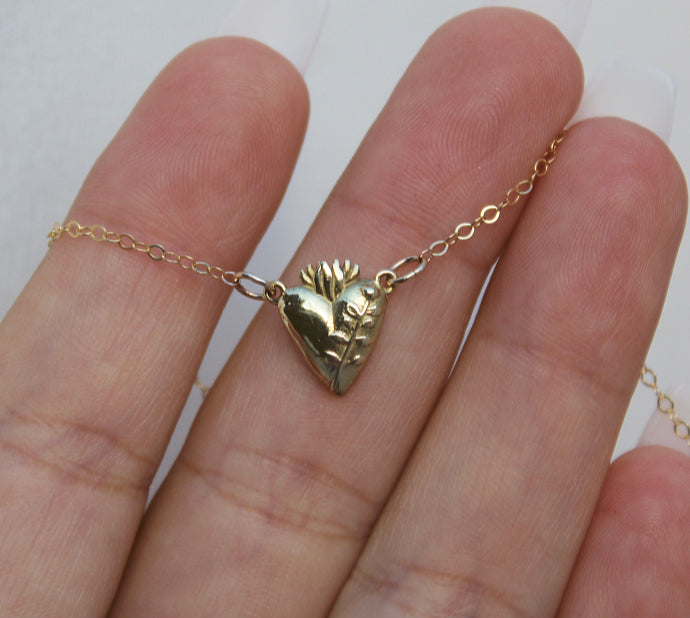 Gold-tone heart pendant necklace close-up with chain links visible