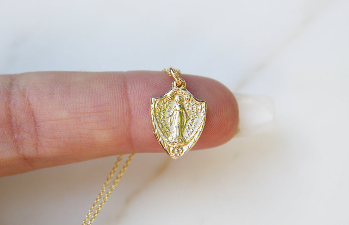 14K gold shield pendant with detailed figure, bail and attached chain