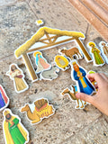Nativity bath toy stable with colorful figurine and animal cutouts scattered