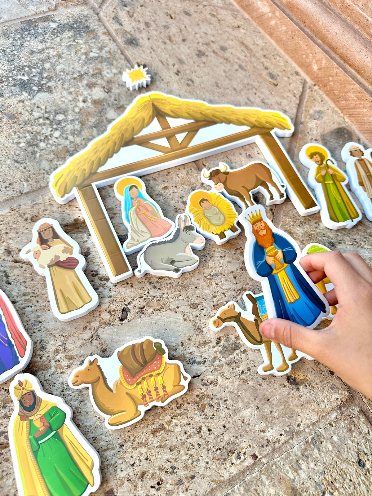 Nativity bath toy stable with colorful figurine and animal cutouts scattered