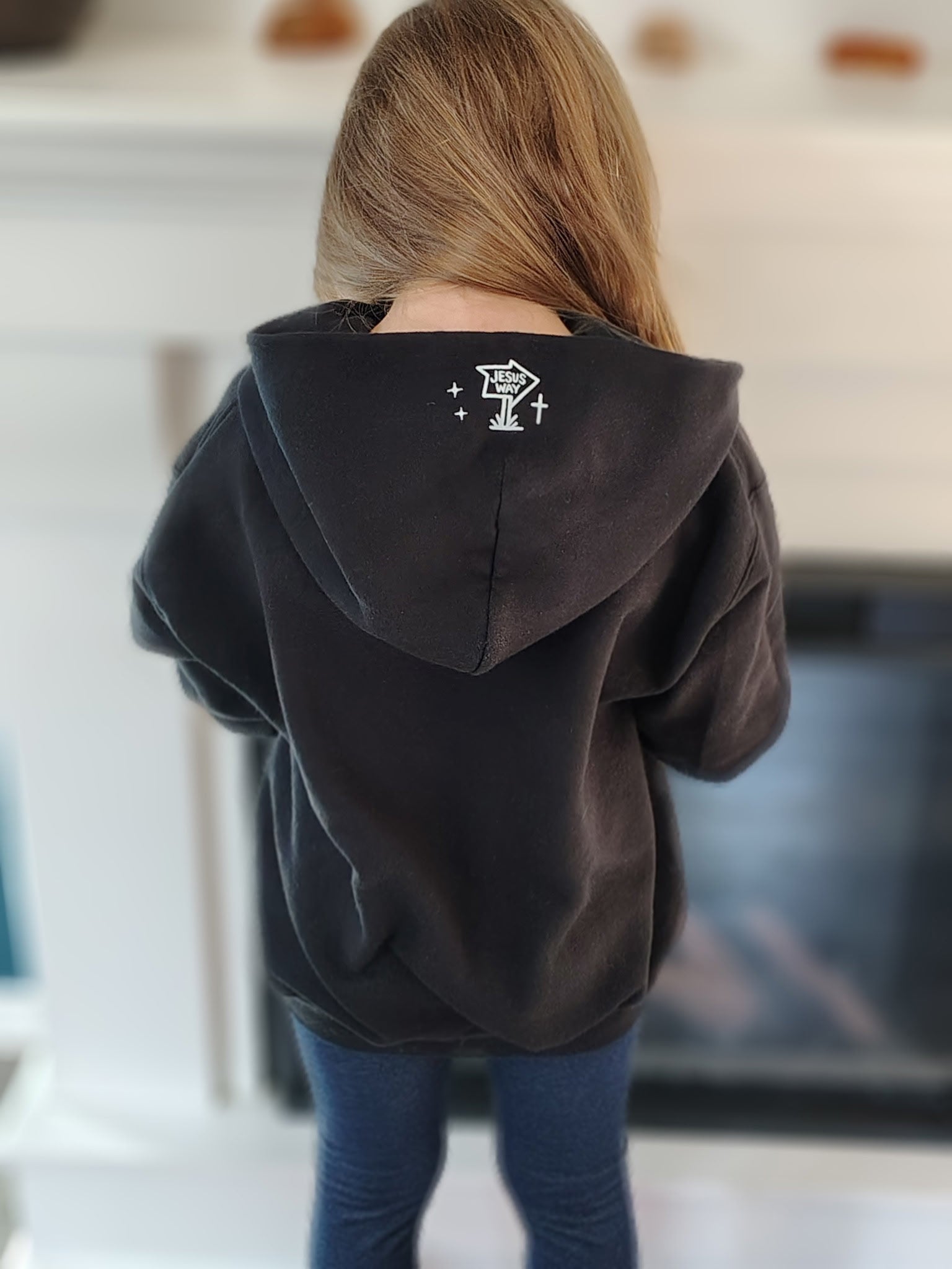 Black kids hoodie showing back graphic print and attached hood