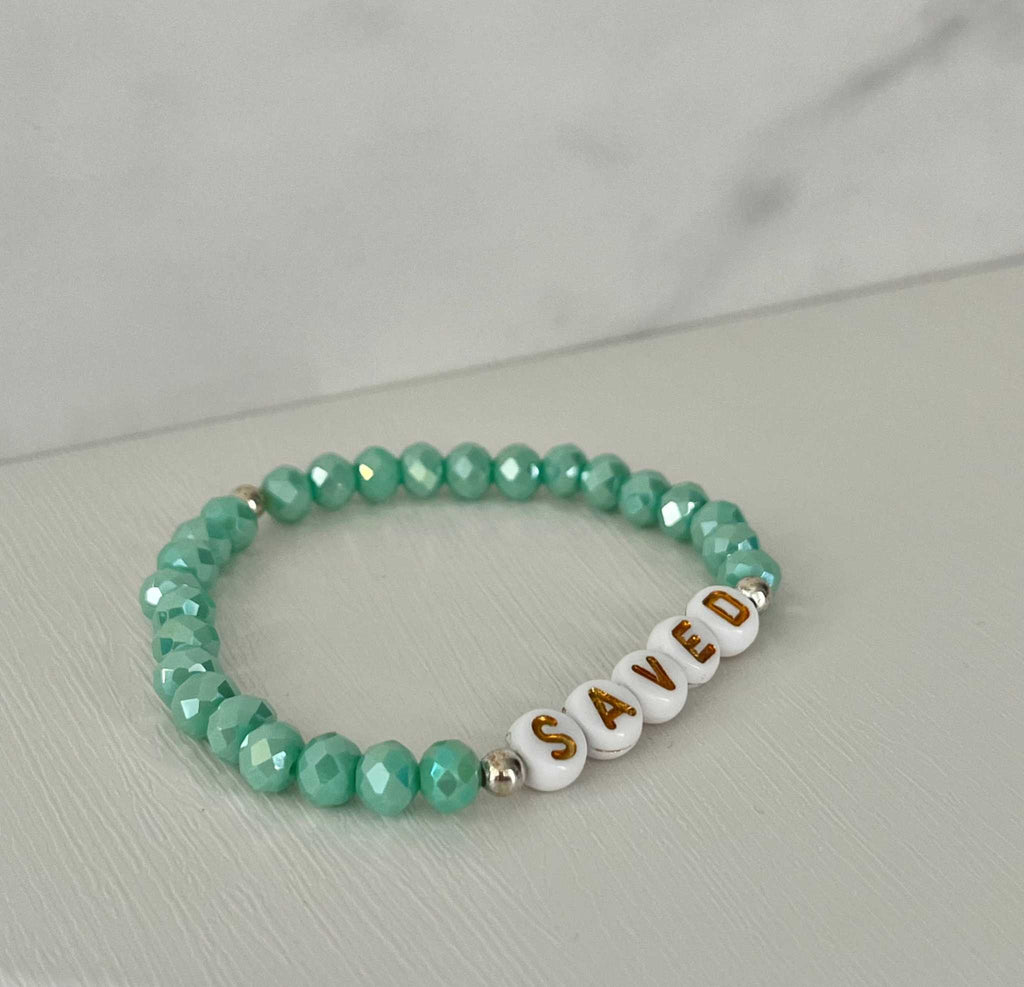 Mint green beaded bracelet with gold-accented 'SAVED' letter beads
