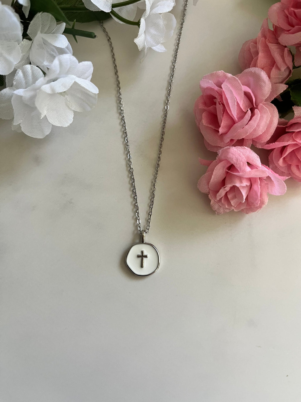 Silver necklace featuring a round cross pendant on a chain