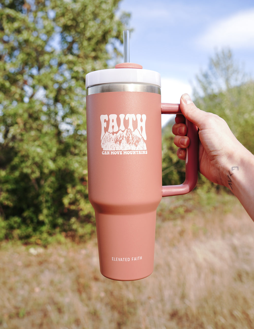 Rose pink 40 oz tumbler with straw lid, handle and “FAITH” logo, held