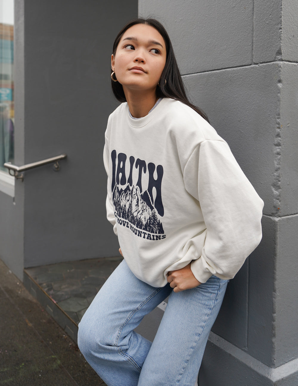 White crewneck sweatshirt featuring the “Faith” mountain graphic, long sleeves
