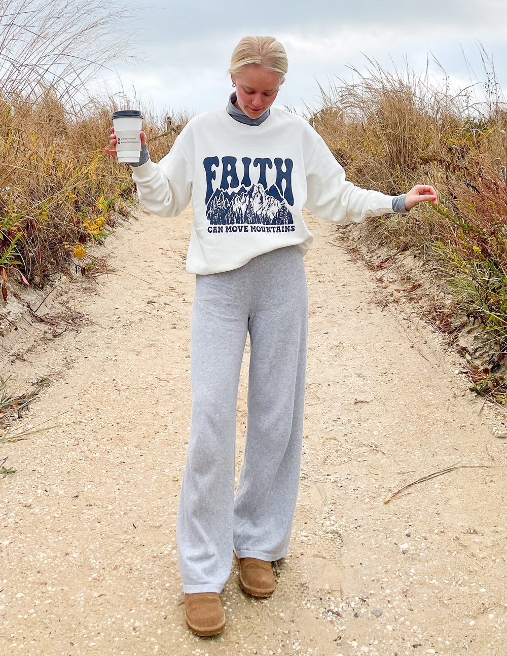 White crewneck sweatshirt with “Faith” mountain graphic and “can move mountains” text