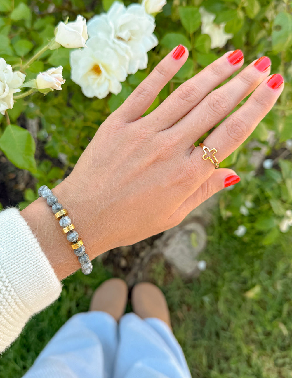 Gray stone bead bracelet with gold spacer beads on wrist