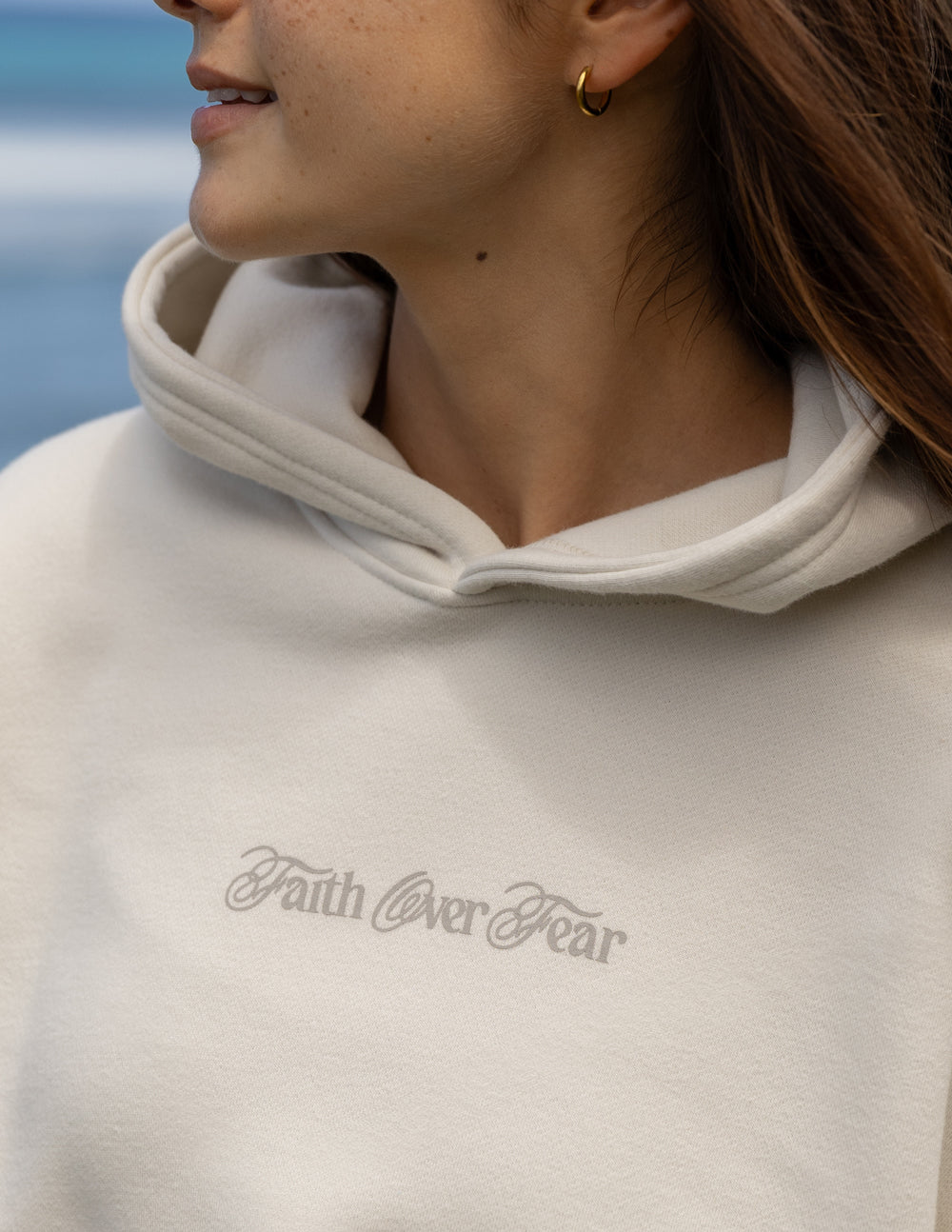 Light hoodie neckline with 'Faith over Fear' script logo