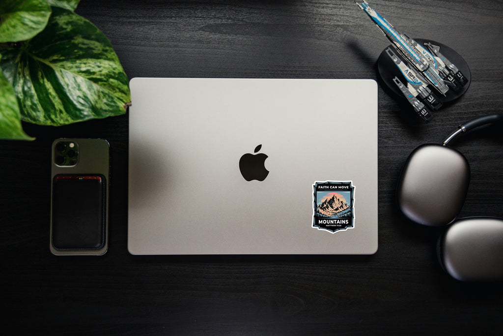 Laptop with Faith Can Move Mountains sticker showing mountains and Matthew 17:20