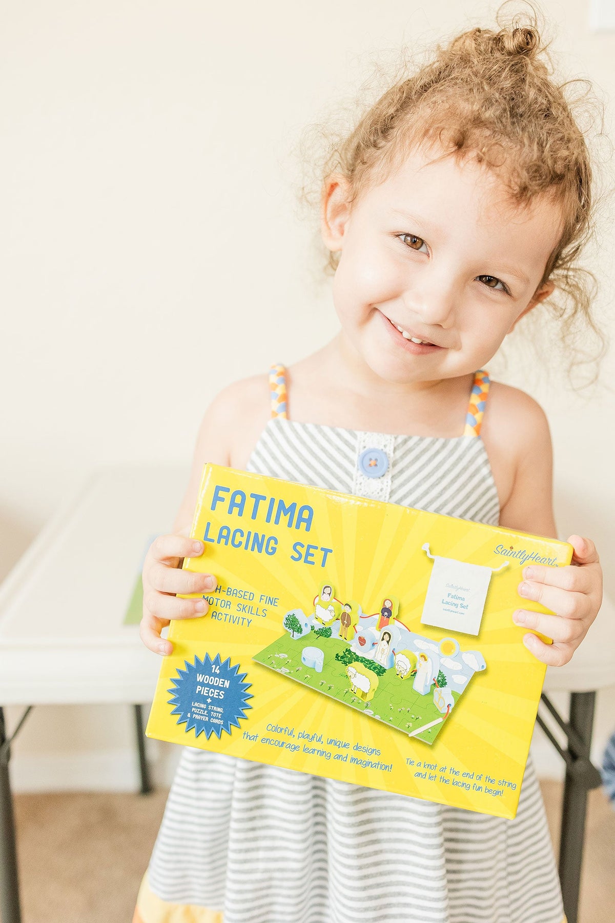 Kids' lacing puzzle board with colorful pieces and instruction booklet held by a child