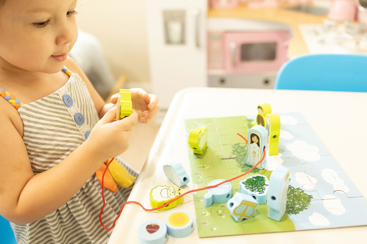 Child playing with a colorful lacing puzzle set featuring cutout figures on the board
