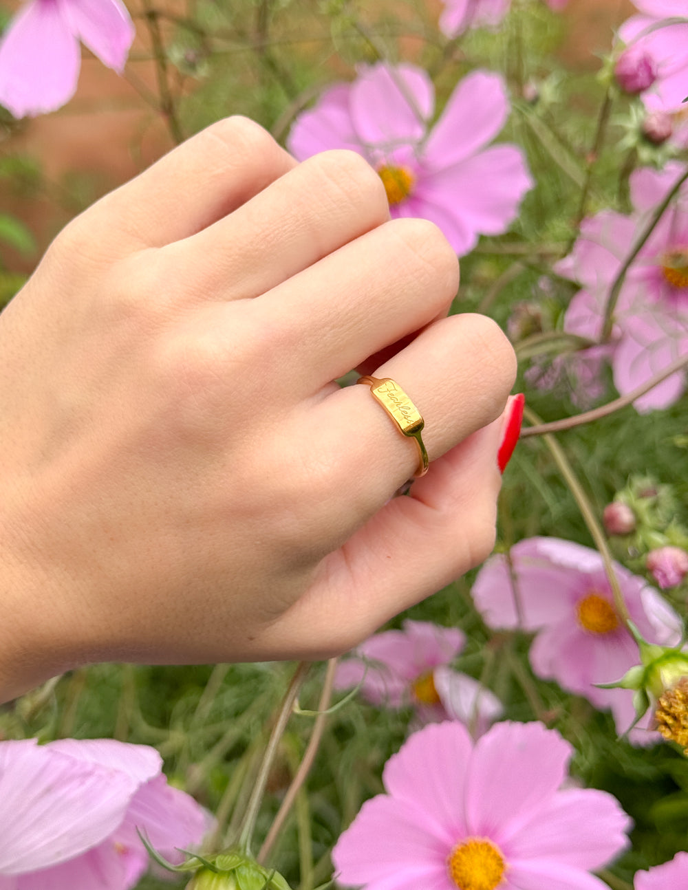 Gold Fearless signet ring centered on hand with slim band