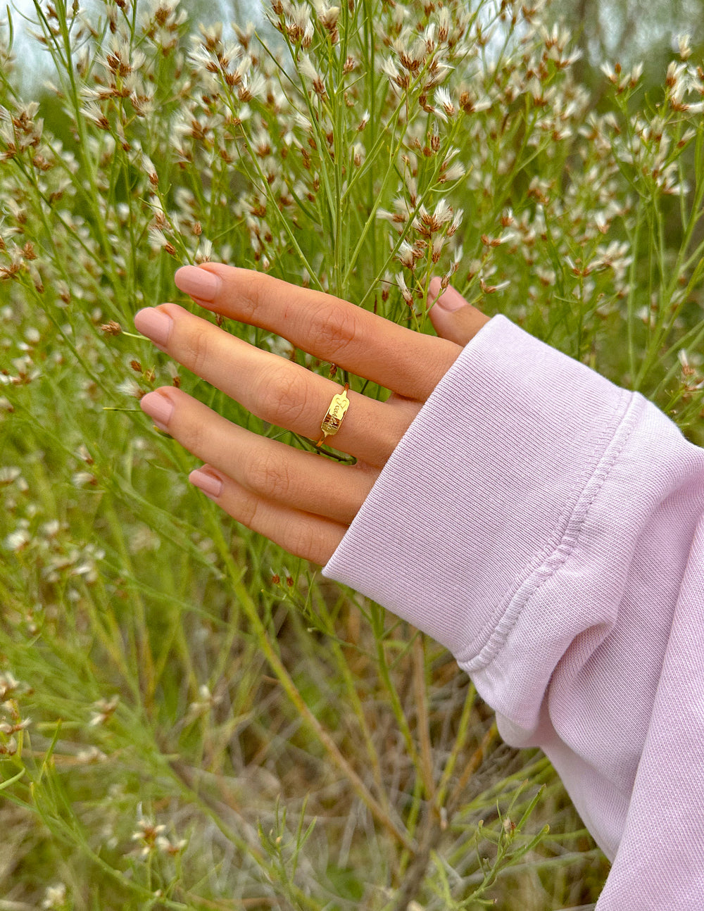 Gold Fearless signet ring on finger
