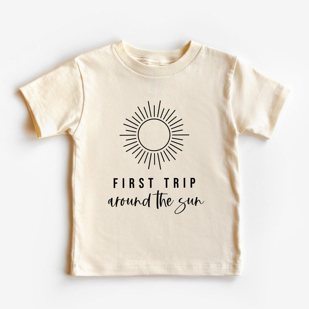 Kids cream cotton tee with sunburst graphic and 'First Trip' text