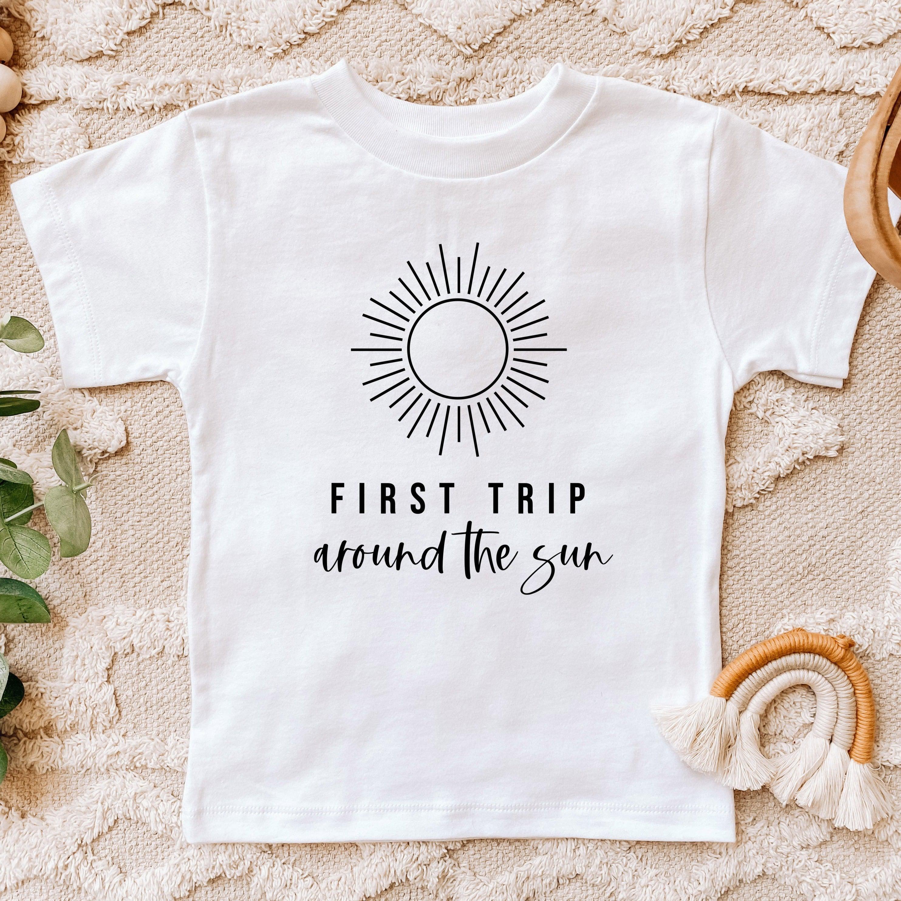 Kids white cotton tee with sunburst graphic and 'First Trip around the sun' text