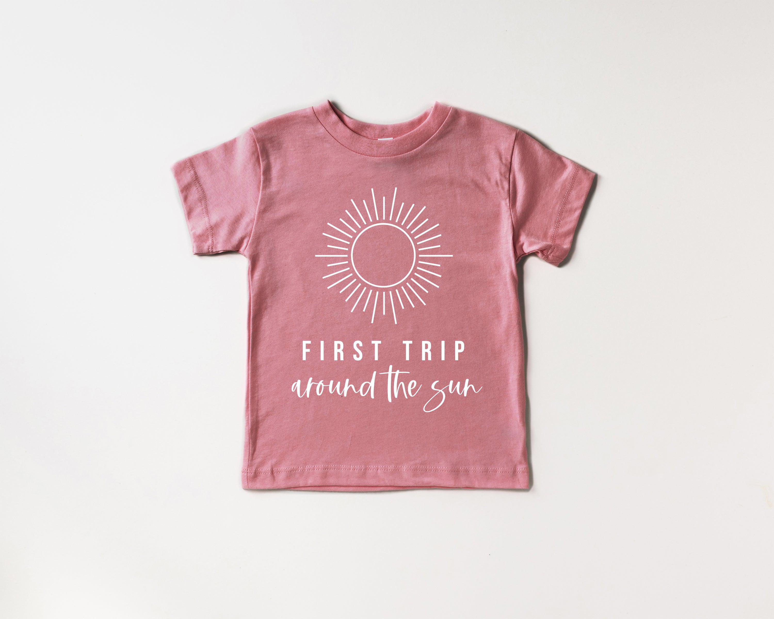 Kids rose-pink cotton tee with sunburst graphic and 'First Trip around the sun' text