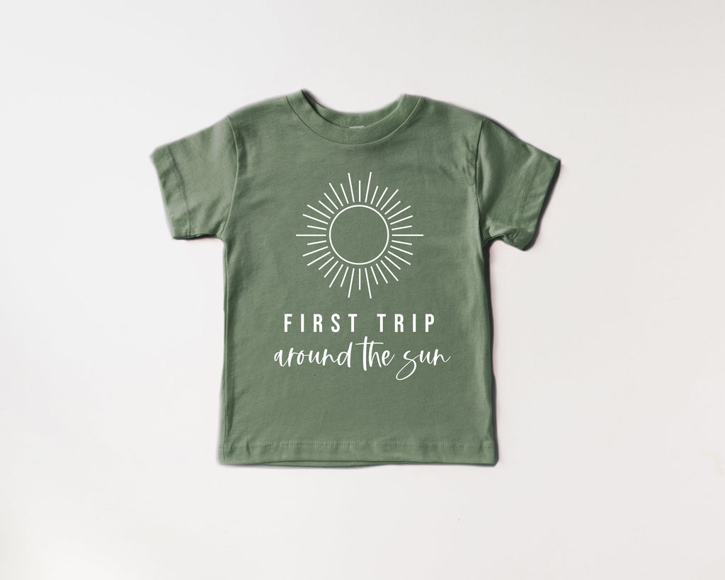 Kids green cotton tee with sunburst graphic and 'First Trip around the sun' text