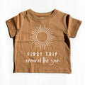 Kids brown cotton tee with sunburst graphic and 'First Trip' text