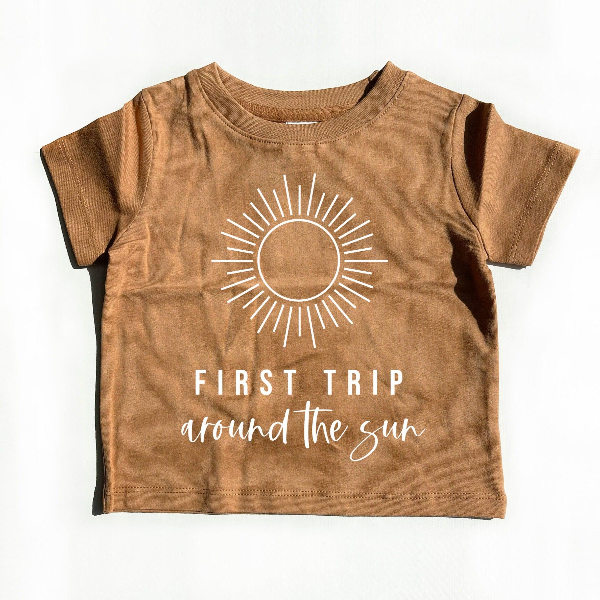 Kids brown cotton tee with sunburst graphic and 'First Trip' text