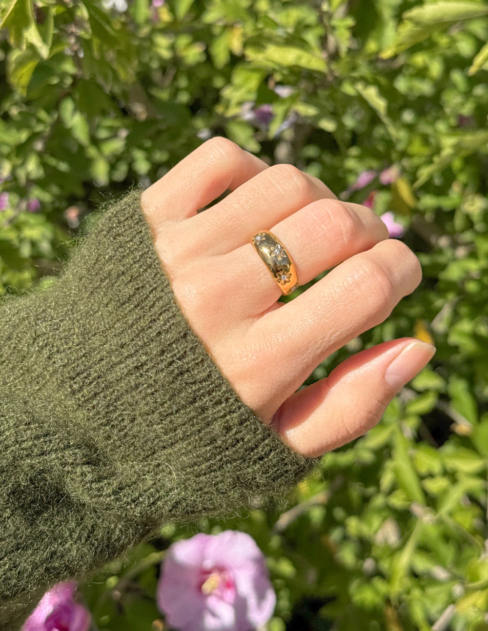 Close-fitting gold-tone floral dome ring with dark stone flower insets