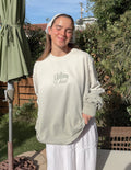 Light cream long-sleeve crewneck tee with 'i follow Christ' front graphic