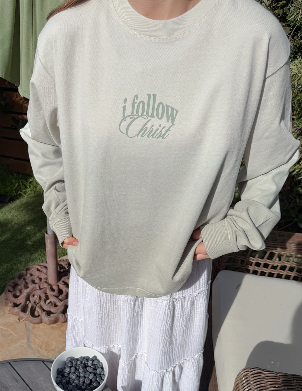 Light cream long-sleeve tee with centered 'i follow Christ' front print