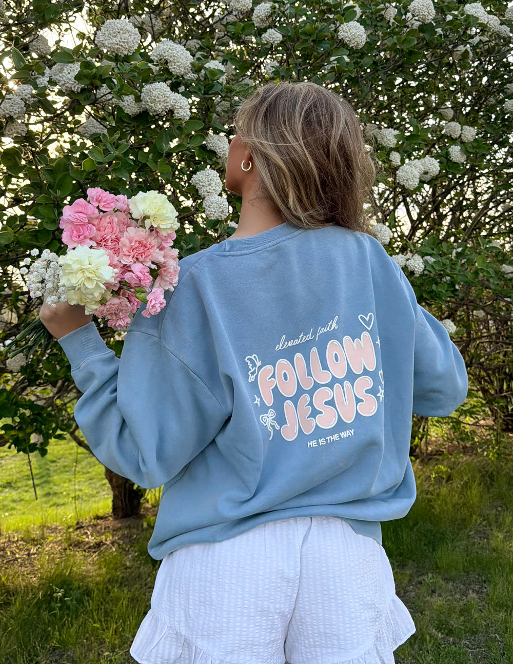 Light blue unisex crewneck sweatshirt, back “Follow Jesus” graphic with hearts