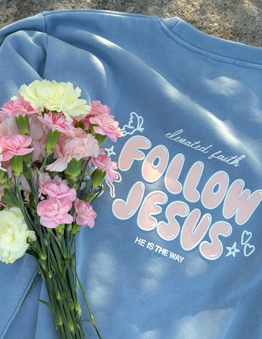 Light blue unisex crewneck sweatshirt, close-up back print reading “Follow Jesus”