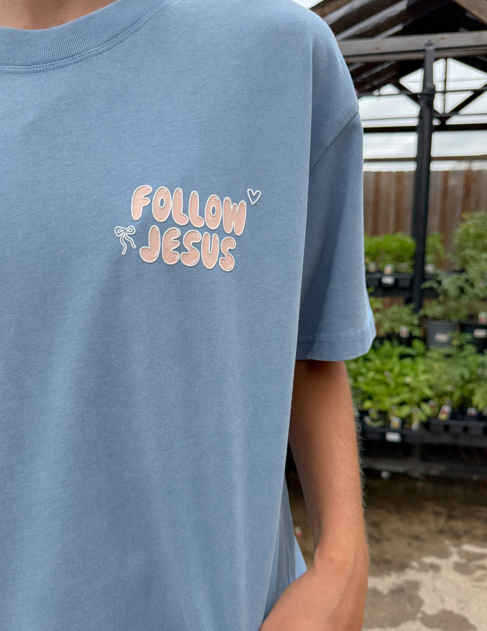 Unisex light blue T-shirt close-up of chest "Follow Jesus" print