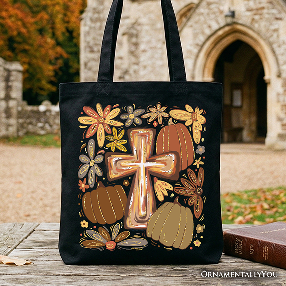 Black tote bag with gold cross, pumpkins, and floral fall design