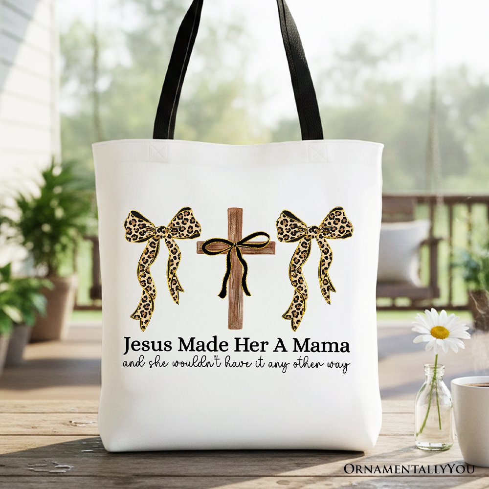 White tote bag with black handles, leopard bow print and cross design on front.
