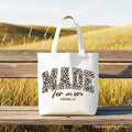 White canvas tote bag with "MADE for more" leopard print text and top handles