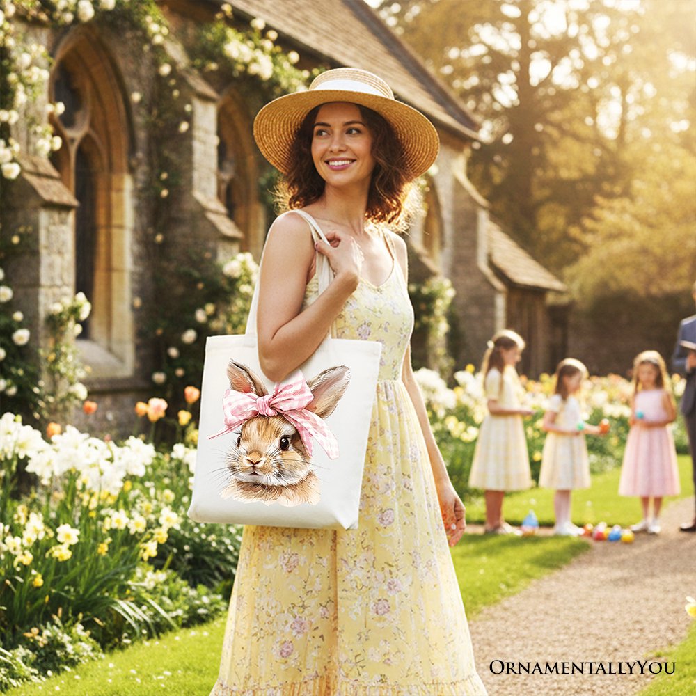 Cream tote bag with watercolor bunny face and pink bow, held by model