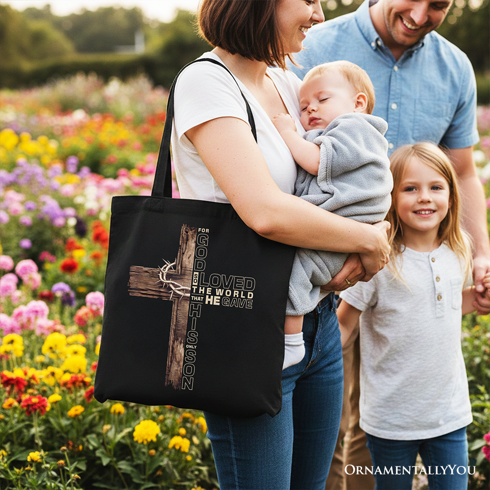 Black tote bag with cross graphic and "Loved the world" lettering