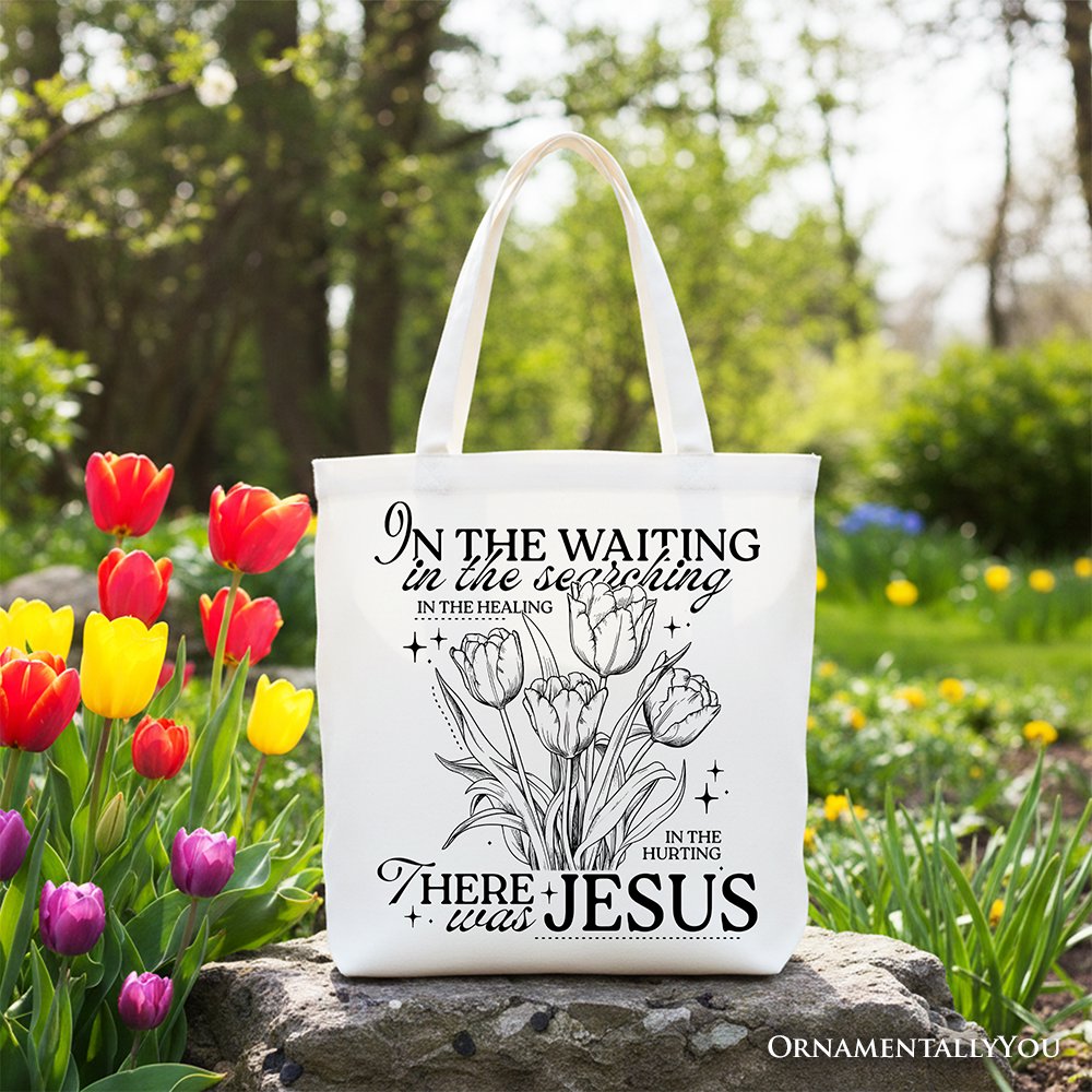 Cream tote bag with black handles and floral scripture print, outdoors, front view