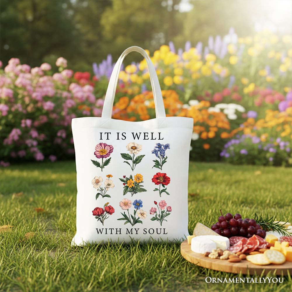 White canvas tote with long handles, colorful floral print and 'IT IS WELL' phrase.