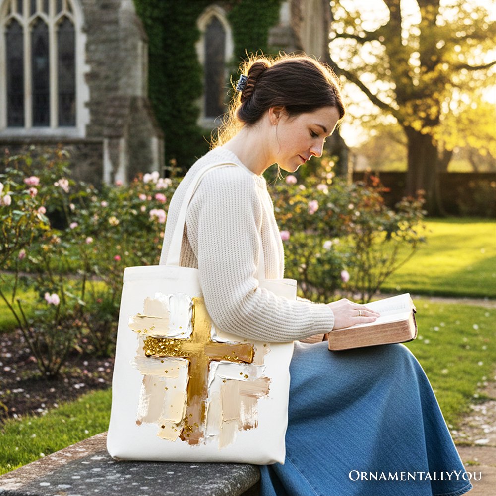 White canvas tote bag with gold cross print, carried by person