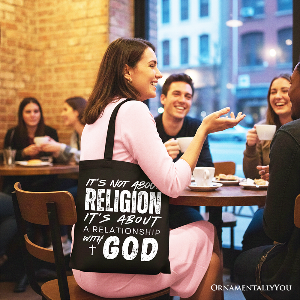 Black tote bag on a dining chair with white text: not about religion, it’s about God.