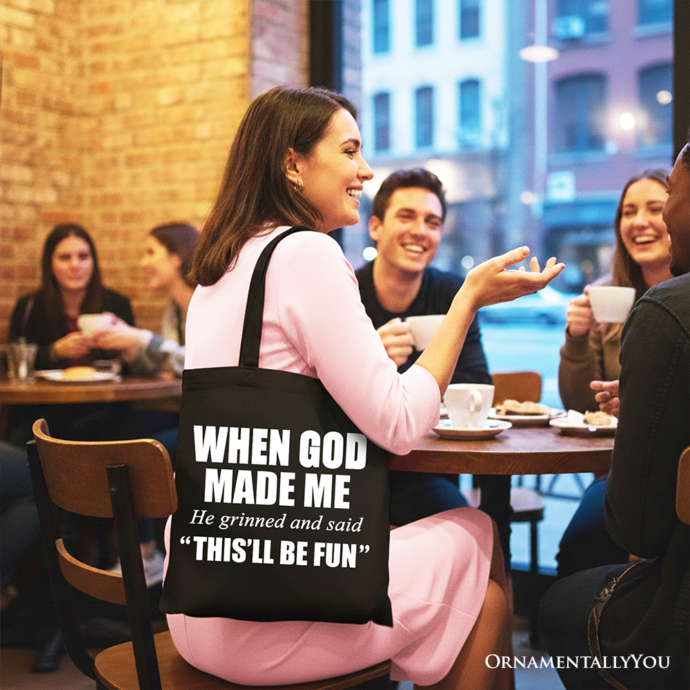 Black tote bag with long handles, “WHEN GOD MADE ME” and “THIS’LL BE FUN” text.