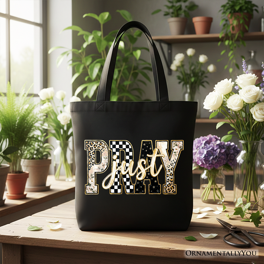 Black tote bag with “Pray” patchwork graphic centered on the front