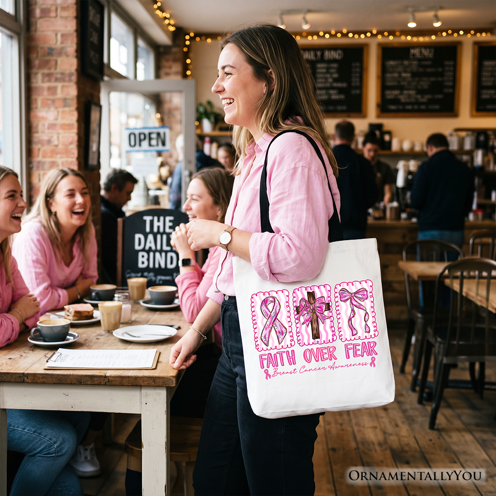 White tote bag with pink 'Faith Over Fear' ribbon print and long black handles