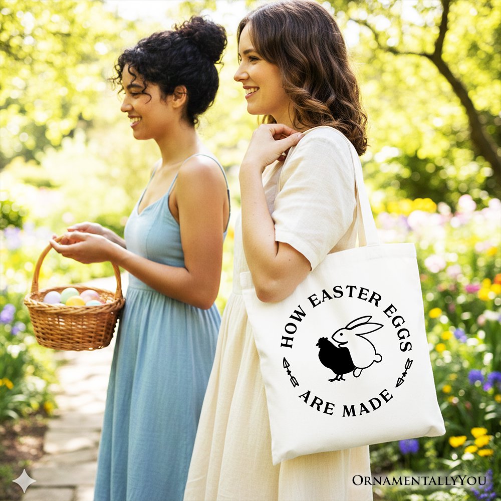 White tote bag with black handles, 'How Easter Eggs Are Made' bunny graphic