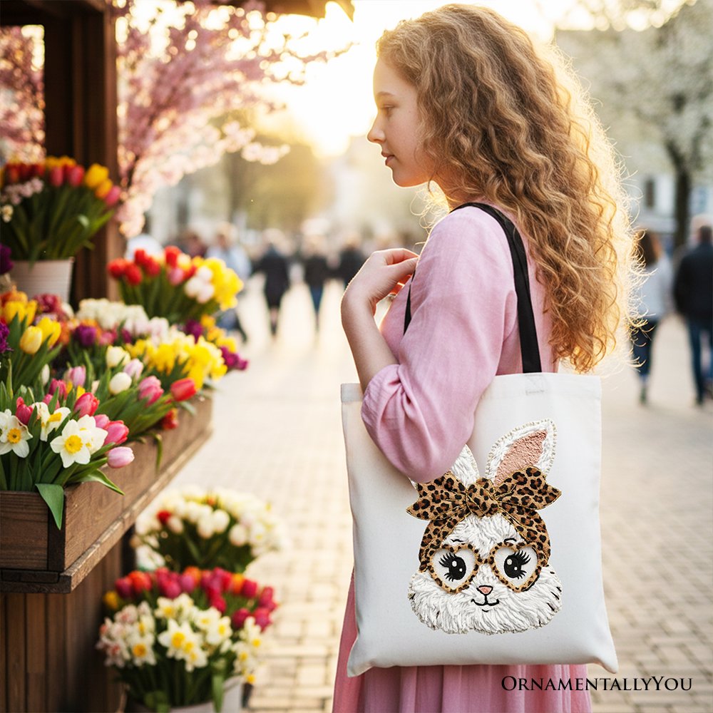 White tote bag with embroidered leopard bow bunny face, worn over shoulder