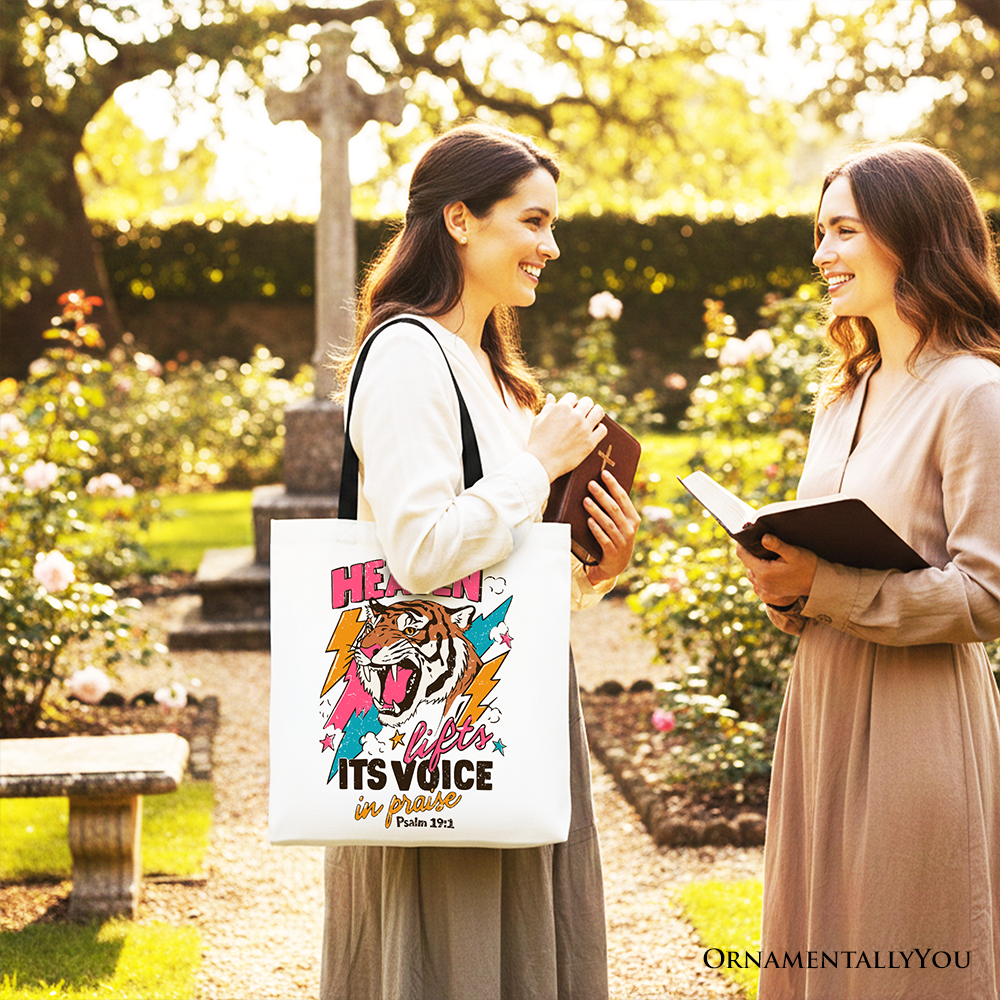 White tote bag worn outdoors with tiger graphic and colorful Christian quote on front.