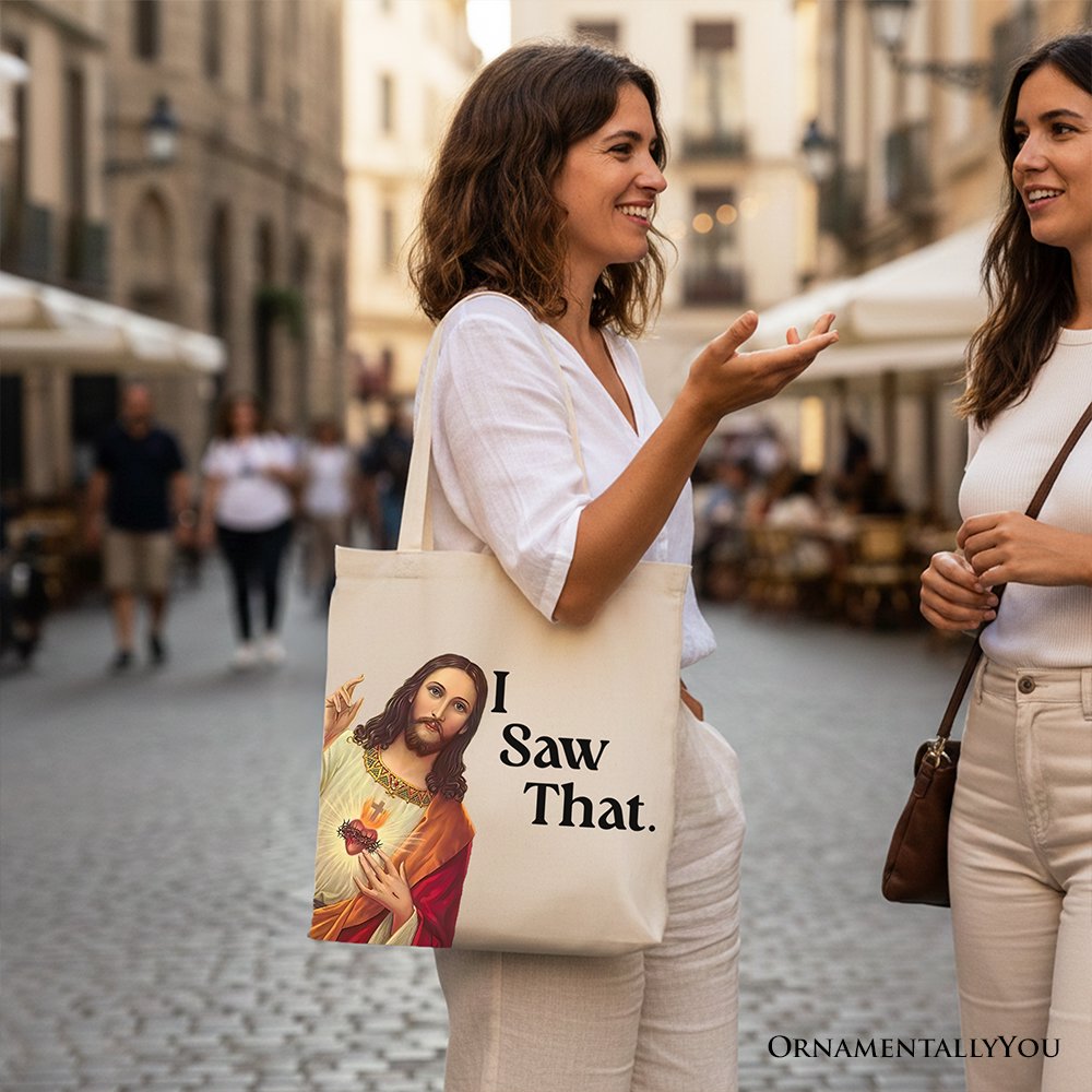 Canvas tote bag with Jesus portrait graphic and “I Saw That.” text, held by person.