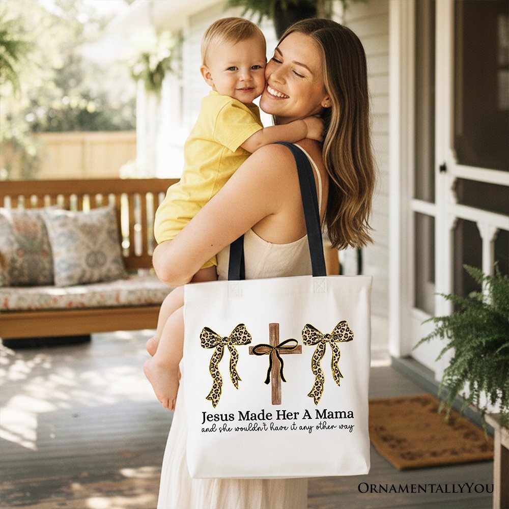 White tote bag with leopard bows and cross print, carried by person indoors.